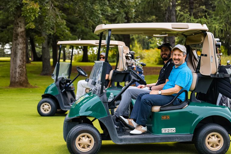 homme souriant dans une voiturette de golf